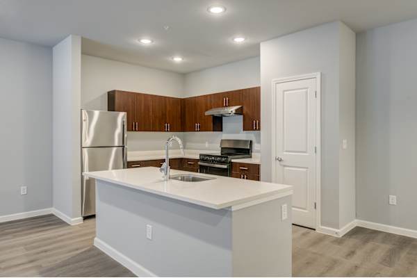 a kitchen with an island and a stainless steel refrigerator